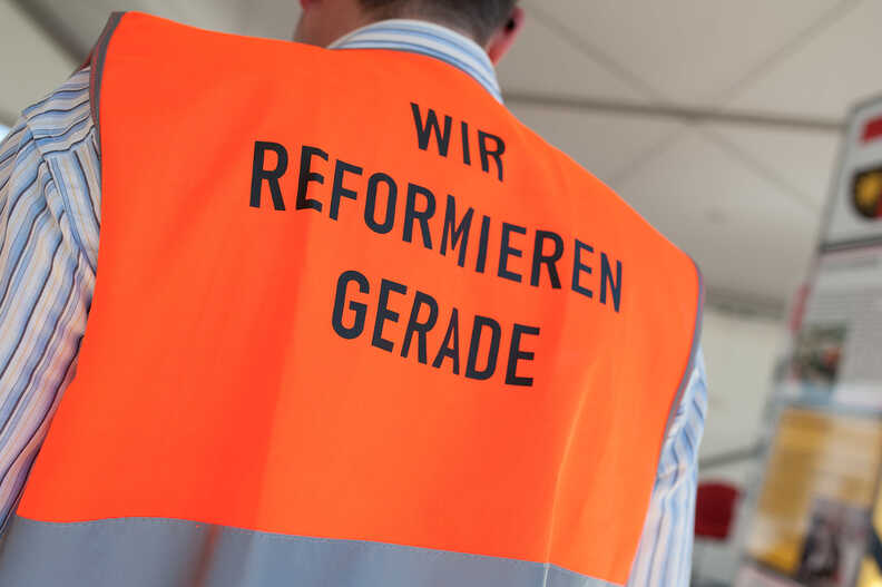 Orange Warnweste mit Aufdruck "Wir reformieren gerade"