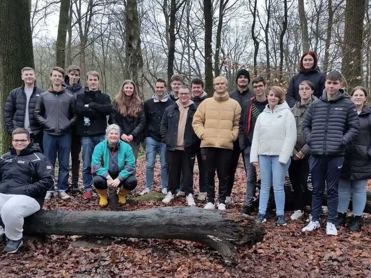 Gruppe Jugendlicher steht im Wald